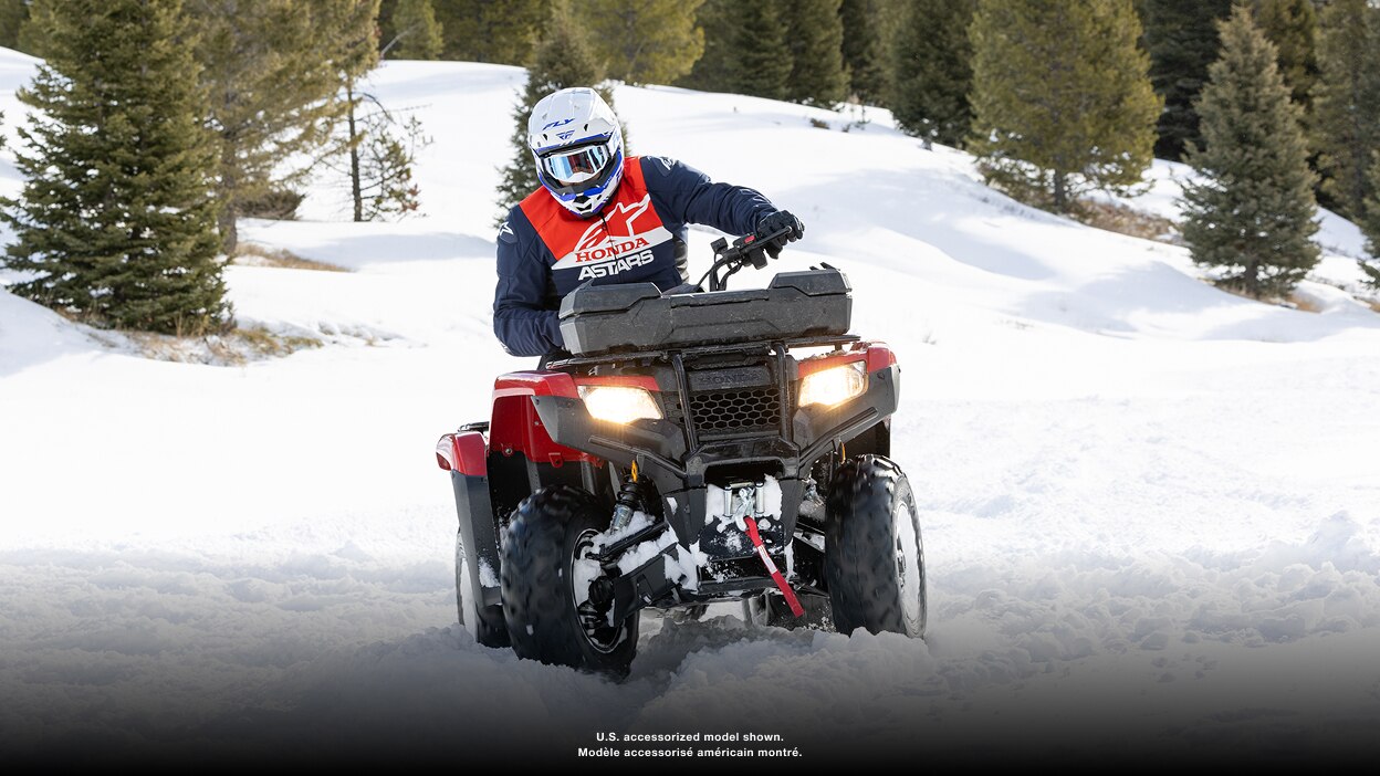 Person riding an ATV in a snowy landscape
