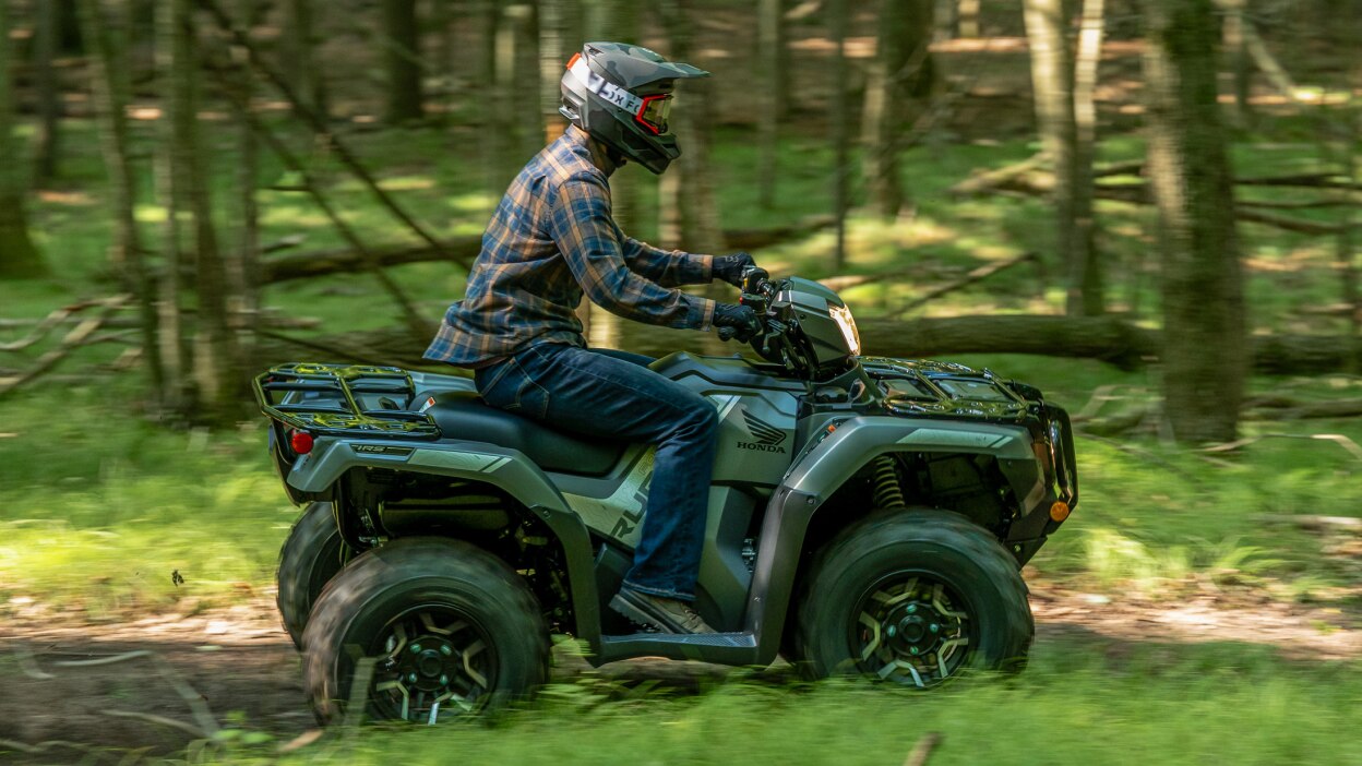 Driver on grey Rubicon going right. Wood landscape in the background.