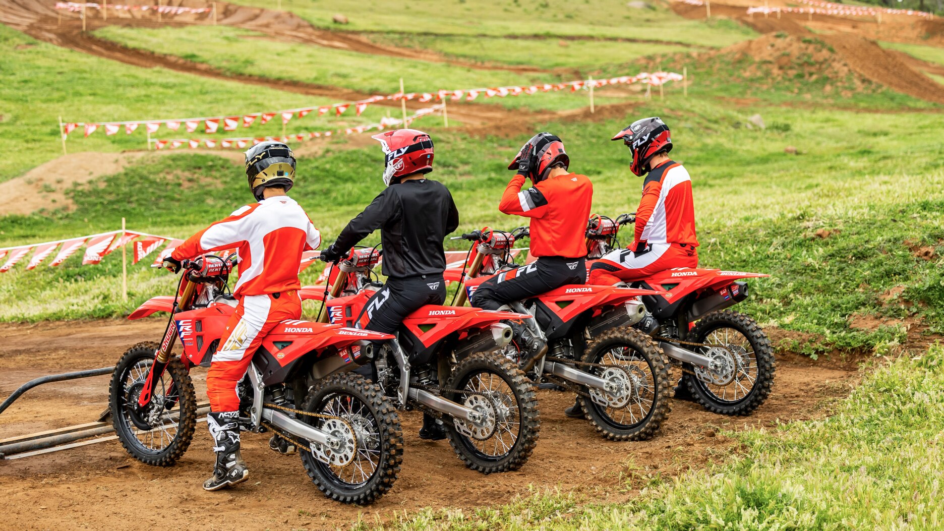 Back of four riders at stand of track.