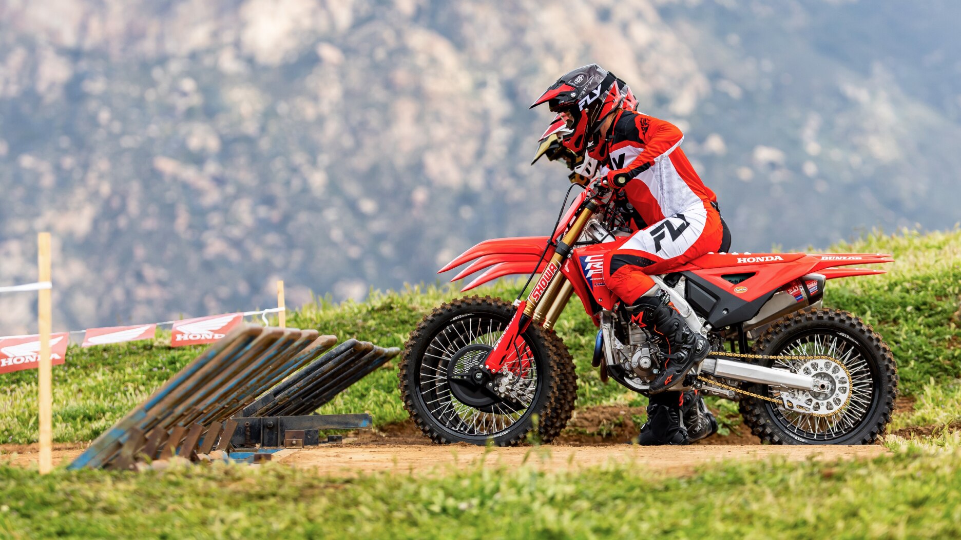 Four riders lined up at the start of track facing left.