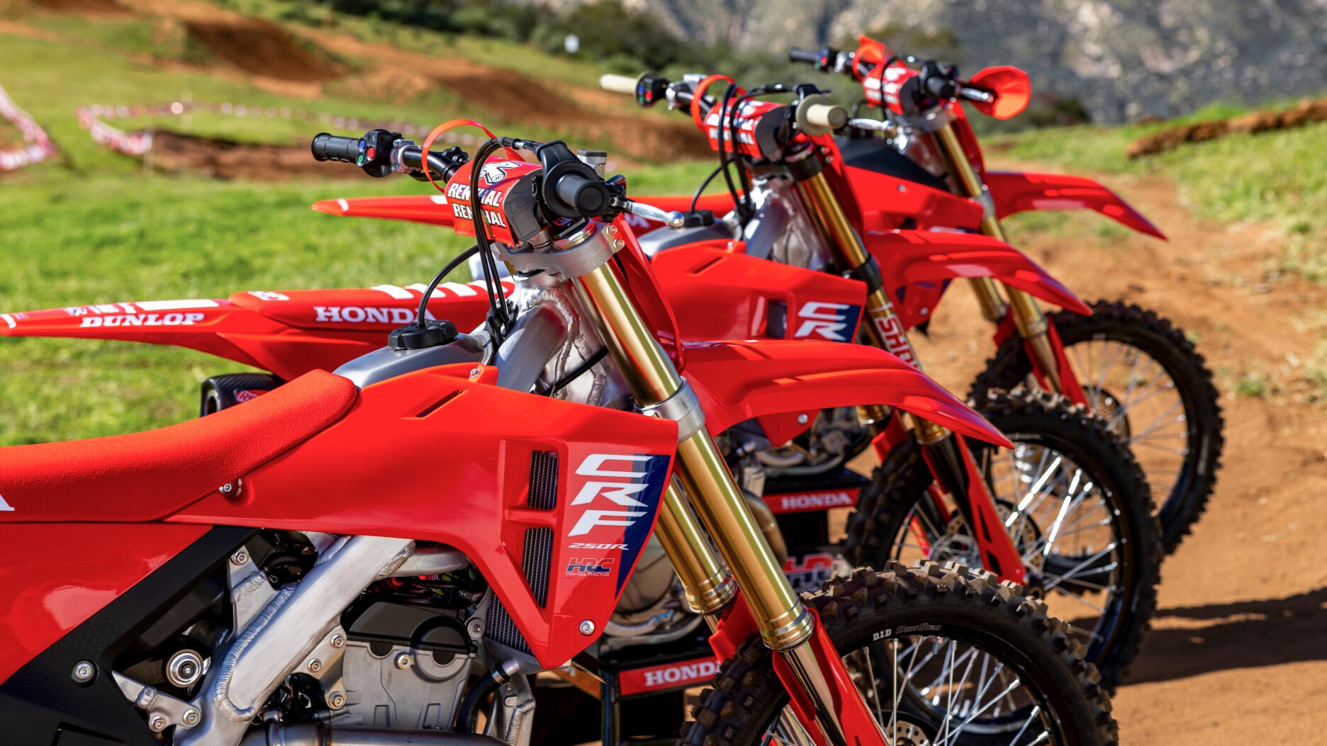 Close up of handles of three competition bikes facing right.