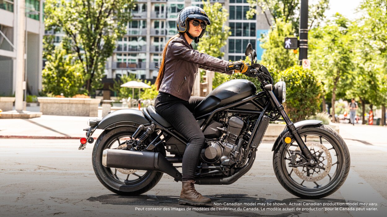 Rider on road, on bike stationary. Buildings, sidewalk and tree in background. Non-Canadian model(s) may be shown. Actual Canadian production model(s) may vary.