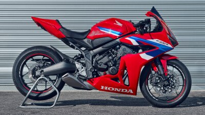 A red Honda sport motorcycle parked on an asphalt surface.