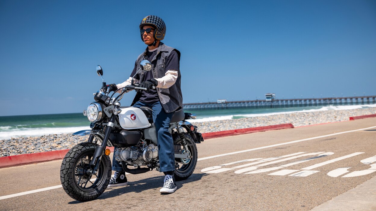 Rider on Monkey in street. Beach in background.