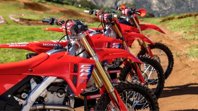 Close-up of the front ends of several red Honda dirt bikes lined up