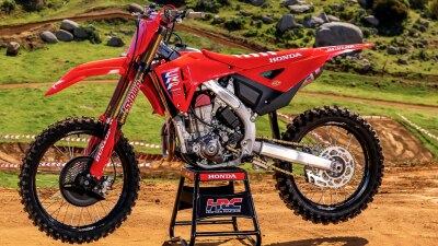 Red Honda CRF450RWE dirt bike parked on a stand outdoors