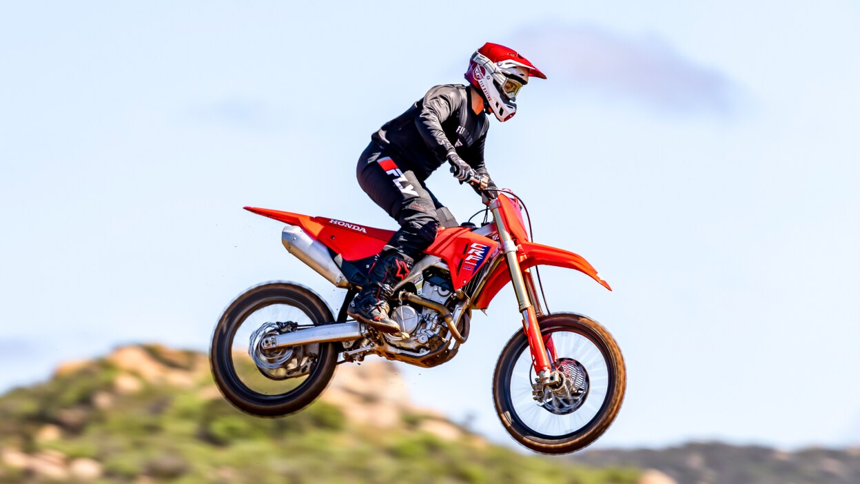 Rider on dirt bike mid air facing right.