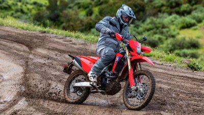 Rider on CRF450L going downhill on dirt track.