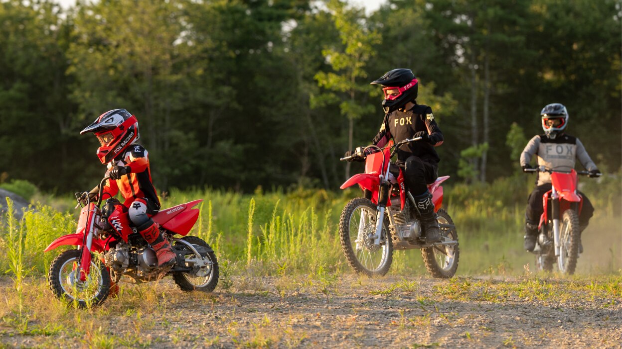 Multiple riders positioned across a wide dirt trail.