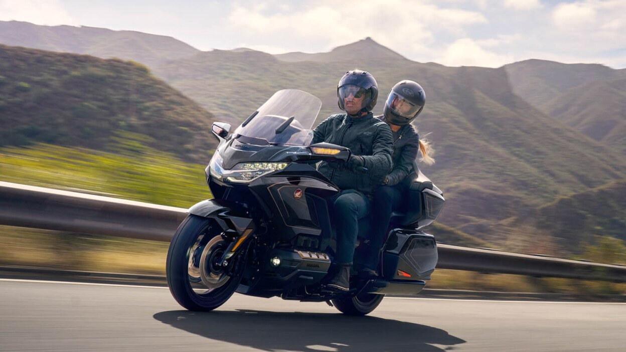 A touring motorcycle navigating a winding road.