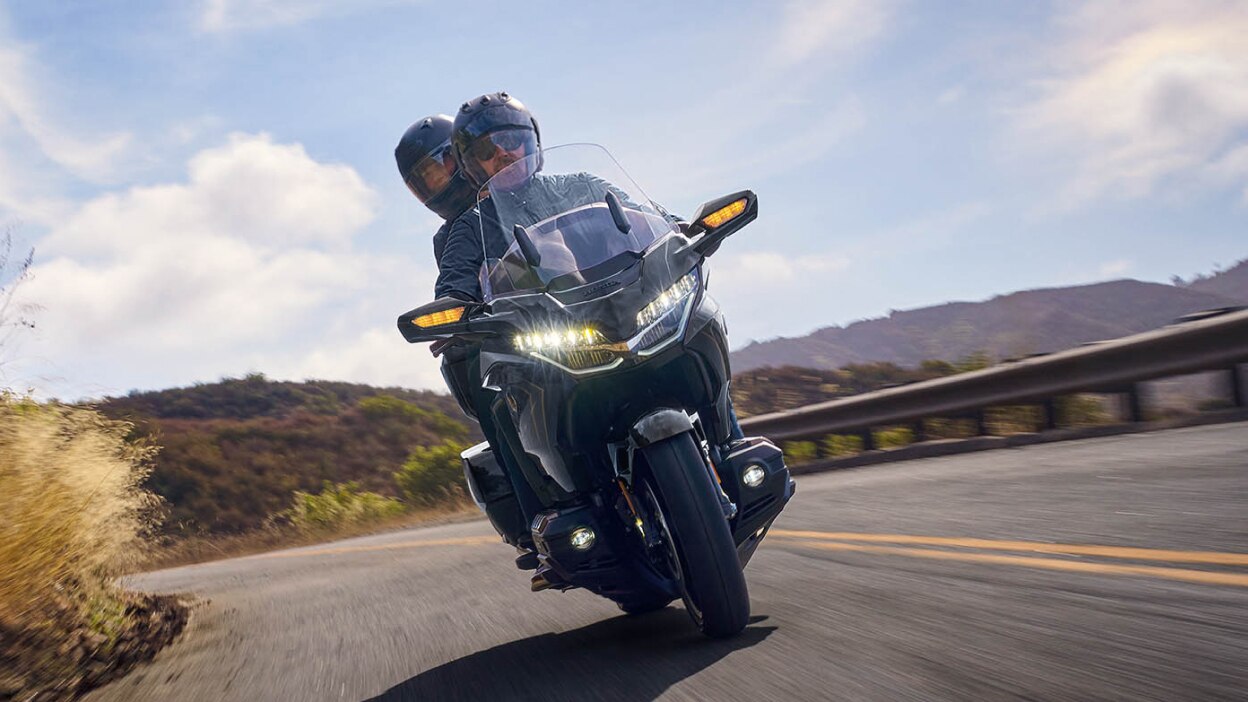 Front view of a touring motorcycle driving on a highway.