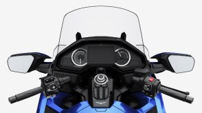 Close-up, rider's perspective of a touring motorcycle's digital dashboard and handlebars.