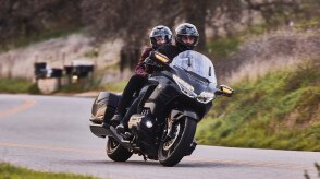 A motorcyclist riding along a scenic coastal highway.