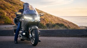 A motorcyclist riding on a scenic mountain road.