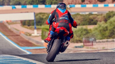 Rider on CBR1000RR-R Fireblade making sharp right turn on race track.