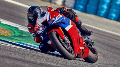 Rider on CBR1000RR-R Fireblade making sharp right turn on race track.