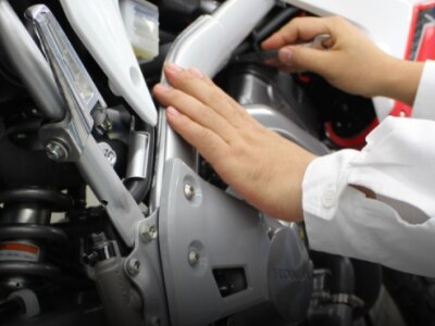 A person doing maintenace on a Honda /Une personne faisant le Maintenace sur une Honda