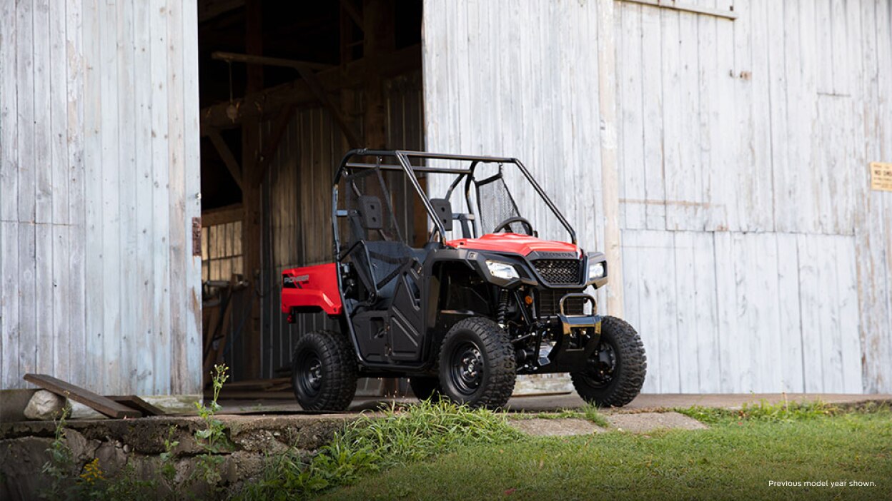 A parked Honda Pioneer 520 outside of a building