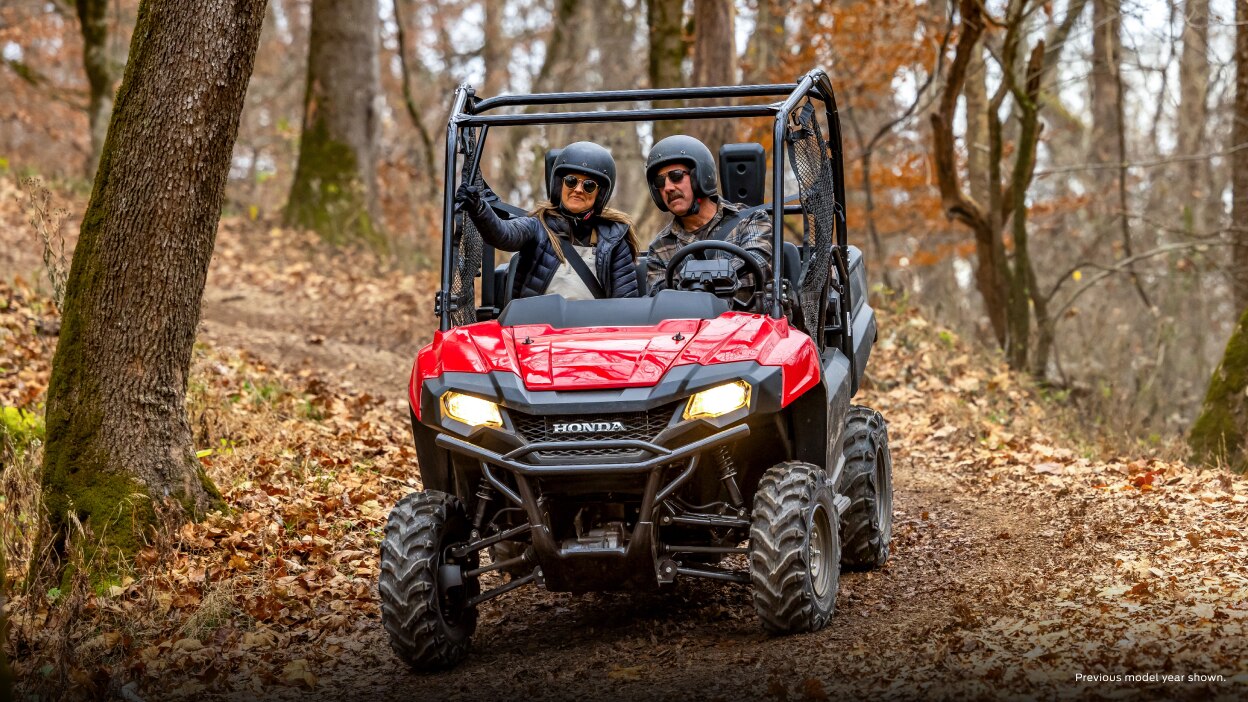 Lifestyle. Driver and passanger on road in woods. Front facing.