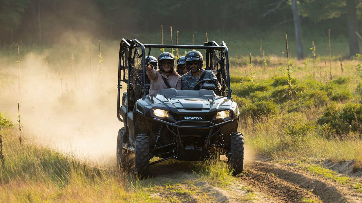 A Honda Pioneer 700 splashing through mud.